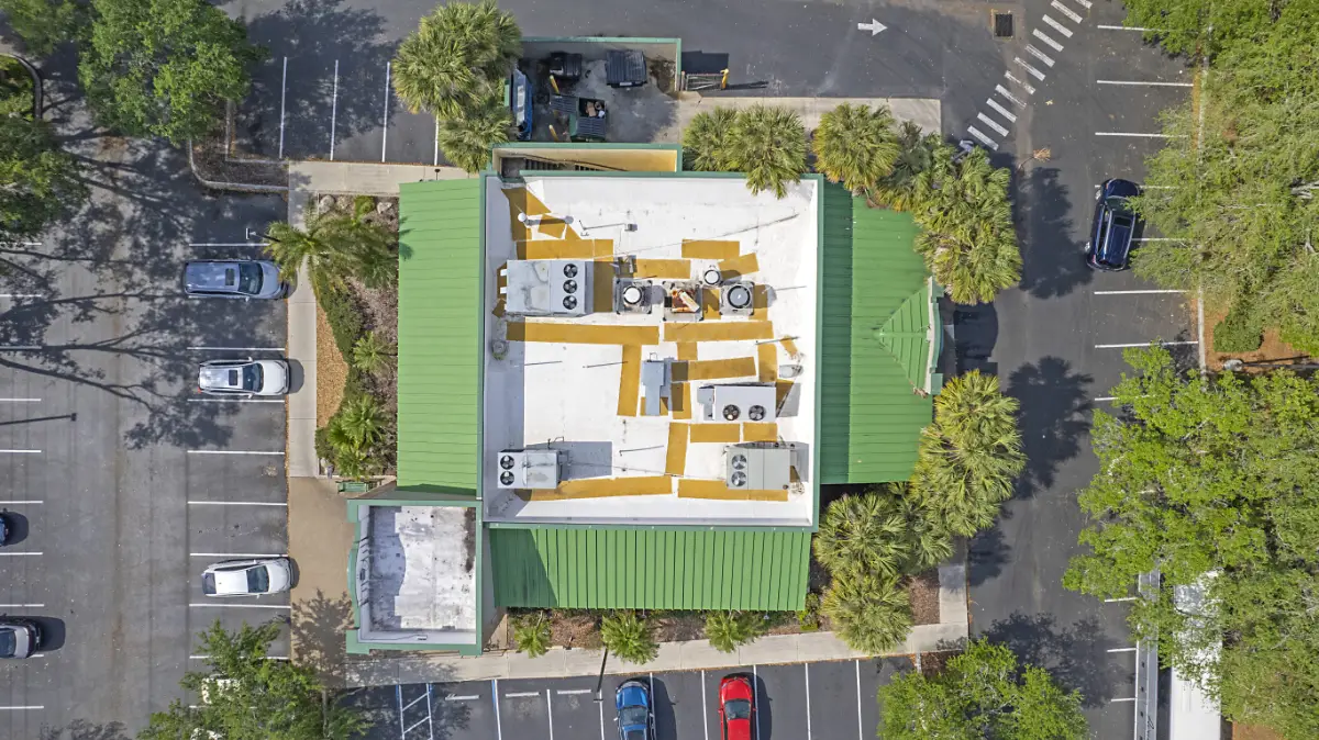 commercial-roof-restoration-conklin-coating-aerial Aerial view of a commercial flat roof with reflective coating during roof restoration on a commercial building